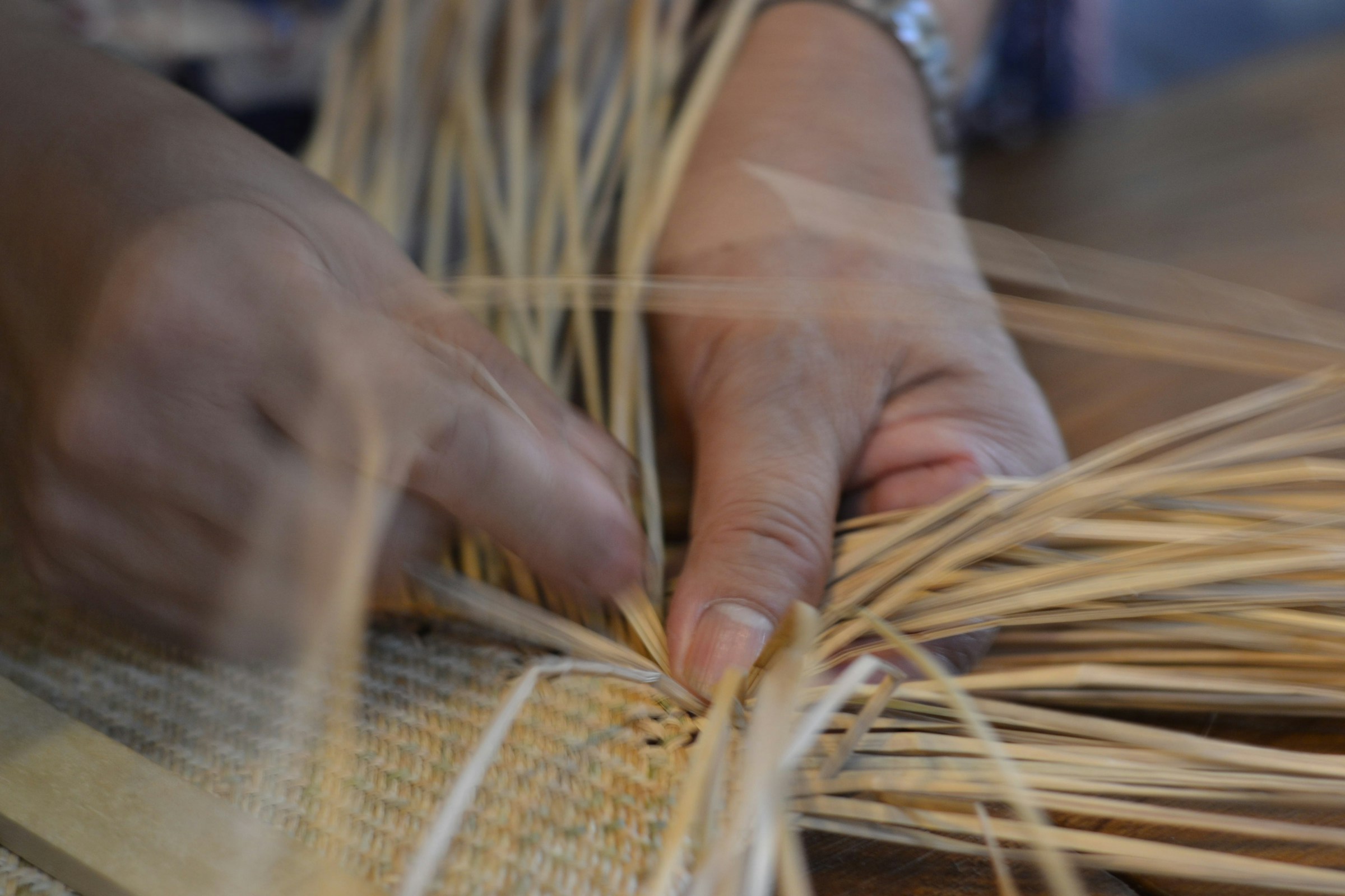 image of someone weaving a basket